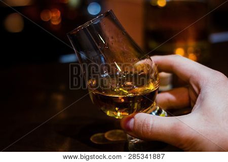 Hand Holds Whiskey In A Special Glass For Tasting With Space For Text