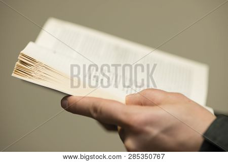 Detail Of Man Reading A Book With Dogears Bookmarks.