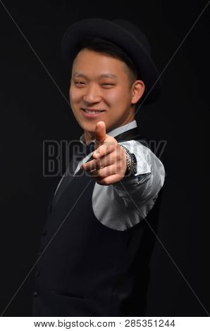 A Smiling Young Asian Man Looks At The Camera And Shows His Finger