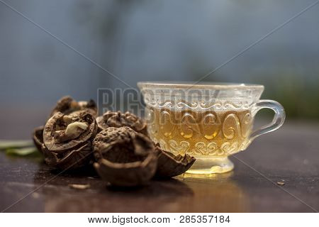 Close Up Of Herbal Organic Tea Of Wall Nut Or Walnut Tea In A Transparent Glass Cup With Raw Wall Nu