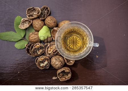 Close Up Of Herbal Organic Tea Of Wall Nut Or Walnut Tea In A Transparent Glass Cup With Raw Wall Nu
