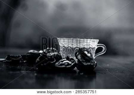 Close Up Of Herbal Organic Tea Of Wall Nut Or Walnut Tea In A Transparent Glass Cup With Raw Wall Nu