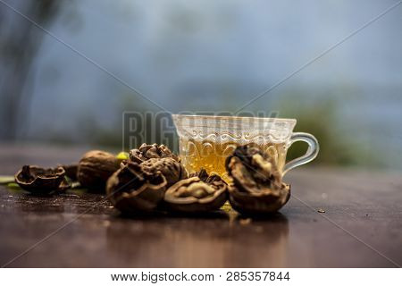 Close Up Of Herbal Organic Tea Of Wall Nut Or Walnut Tea In A Transparent Glass Cup With Raw Wall Nu