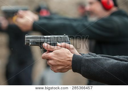 Close-up Detail View Of Shooter Hold Handgun In Row Group Of People On The Shooting Range