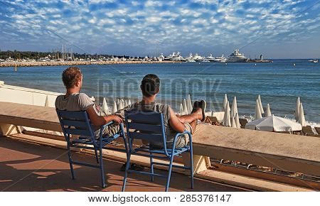 Cannes, France -  July 5, 2014: Two Friends Relaxing In Chairs On Croisette Promenade In Cannes, Fra