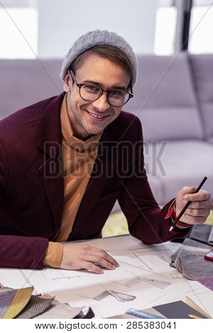 Smiling Fancy Adult Gentleman Energetically Working On Drawings In Office
