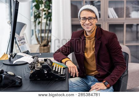 Fanciable Young Dark-haired Man Posing At Desk With Typewriters