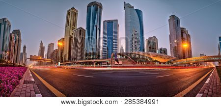 Dubai skyline during sunrise with shining traffic road, United Arab Emirates.