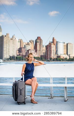 Pretty, businesswoman on a boat to NYC with her travel lugagge