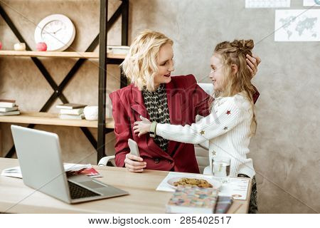 Long-haired Cheerful Little Girl Bringing Cookies To Her Busy Mother