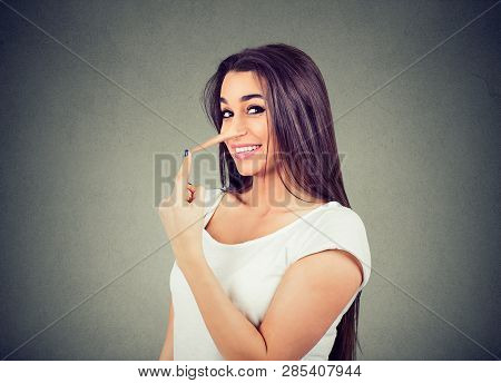 Happy Liar Woman With Long Nose Isolated On Gray Background. Human Emotions, Feelings.