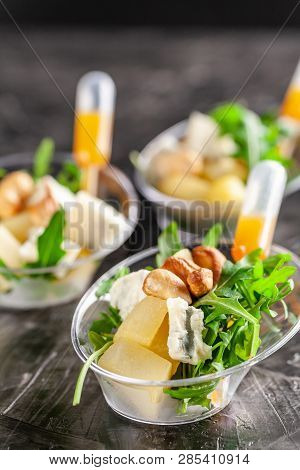 Modern European Appetizer. Mini Salad With Gorgonzola, Pear And Roasted Cashews. Orange Dressing In