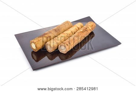 Fresh Burdock Root Or Gobo On Black Plate With White Background
