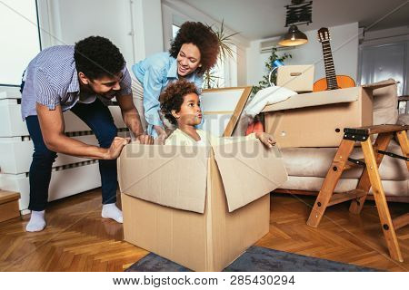 African American Family, Parents And Daughter, Unpacking Boxes And Moving Into A New Home, Having Fu
