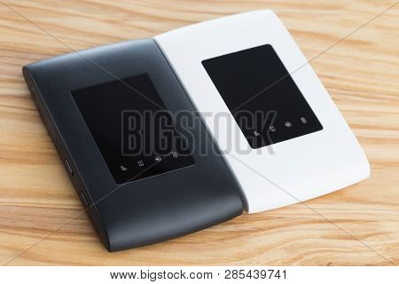 Two Portable Routers On The Table. 4g Routers On A Wooden Surface.