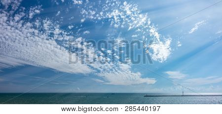 The Sky With A Little Cloudiness Over The Sea. Breakwater And Lighthouse In The Sea. Copy Space Back