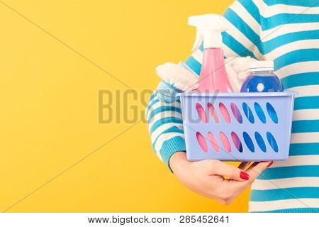 Home Cleaning Products. Housekeeping Concept. Woman Holding Basket With Cleanup Supplies. Copy Space