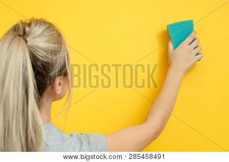 Organized Home Cleanup. Spotless Cleaning. Woman With Sponge Wiping Imaginary Spot.