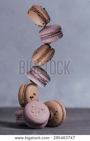 Sweet French Macaroons Stacked On Grey Concrete Background. Pastel Colored Balansed Macaroons. Pyram