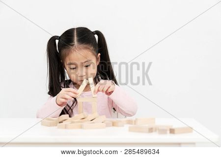 Young Little Cute Asian Girl Build A House From Wooden Block Construction, Wood Toy, Jenga House On 