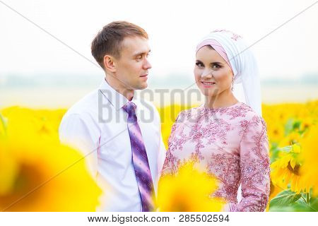 Smiling Young Islamic Couple Portrait On Sunflowers Field