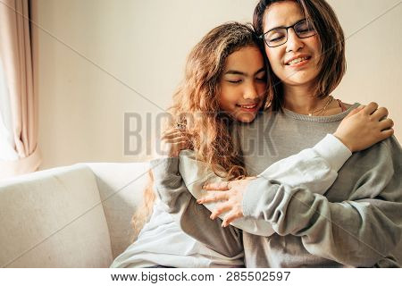 Senior Mom And Her Daughter Are Hugging, Smiling And Dringking A Warm Coffee In Some Morning.