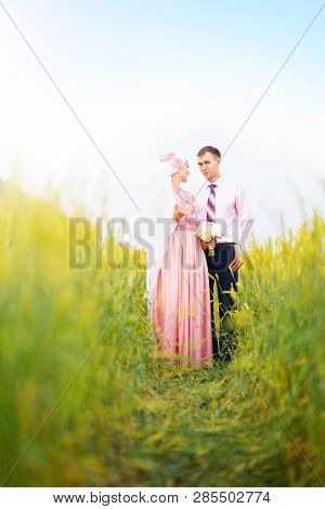 Smiling Young Islamic Couple Portrait On Sunflowers Field