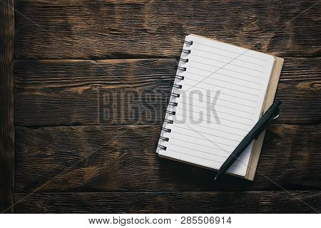Blank Notepad With Empty Paper Sheets On The Brown Wooden Table Background.