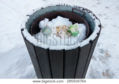 Russian Rubbles In The Trashcan In Winter On White Snow Background. Concept Of Money Waste, Inflatio