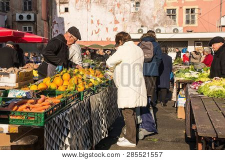 Zagreb, Croatia - December 29th 2018. A Stall Holder Serves A Customer At The Dolac Fresh Fruit And 
