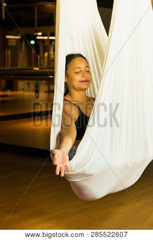 Young Woman Practicing Aerial Yoga In Fitness Studio