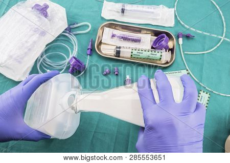 Nurse Filling A Bottle Of Enteral Nutrition, Palliative Care, Conceptual Image, Horizontal Compositi