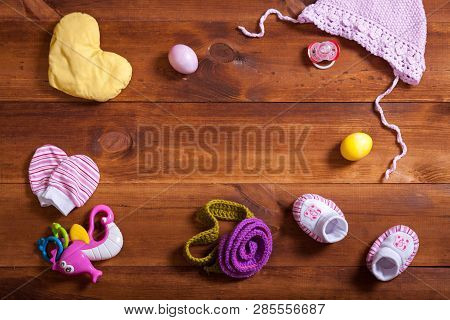 Baby Clothes Set, Knitted Cotton Clothing, Kid Toys And Accessories On Brown Wooden Background, Chil
