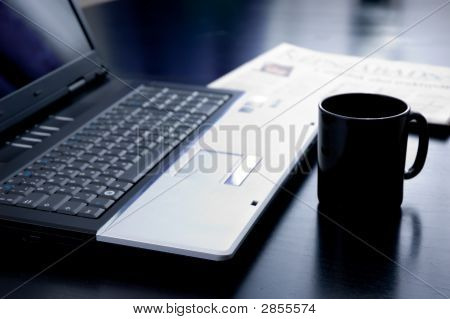 Natura morta con Coppa del computer portatile e un giornale