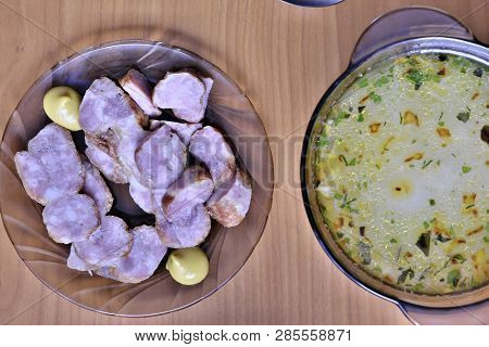 Slicing Homemade Pork Sausage On A Plate And A Plate Of Vegetarian Millet Soup Shot From Above On Th