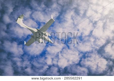 A Small Private White Plane With Screws Flies On The Background  Blue Sky With Clouds