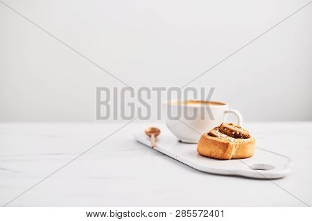 Freshly Baked Cinnamon Roll With Spices And Cocoa Filling And Coffee Or Cappuccino On White Serving 