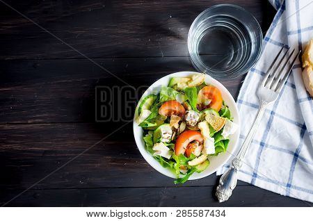 Fresh Light Green Salad With Cucumber, Lettuce, Avocado, Tomatoes, Cheeseand Sseeds And Glass Water 