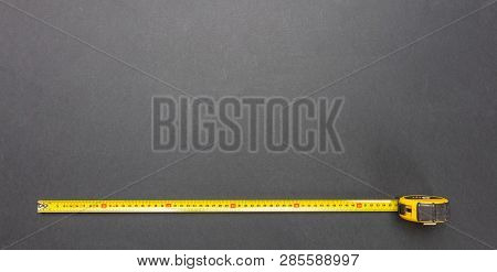 Yellow Measure Tape Isolated On Black Color Background, Top View, Copy Space