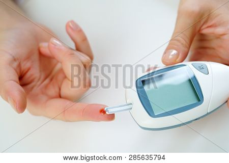 Photo of man's hand with glucometer