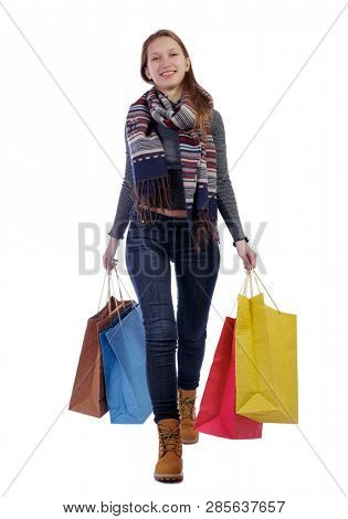 Front view of a woman walking with shopping bags. beautiful girl in motion.  Frontside view of person.  Shopping  people collection. Isolated over white background. Smiling girl in carries shopping