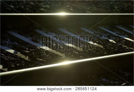 Railroad Tracks For Train In Percpective With Reflection From Sun.