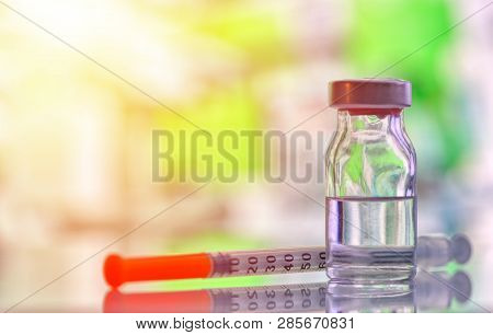 Closeup Of Medicine Vial Or Flu, Measles Vaccine Bottle With Syringe And Needle For Immunization On