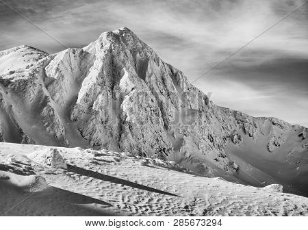 Bucura II Peak, 2372m. Winter alpine landscape in National Park Retezat, Carpathians, Romania, Europe. Snow covered moutains scenery