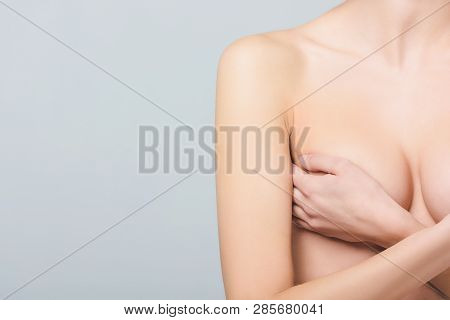 Partial View Of Nude Girl Covering Breast, Isolated On Grey