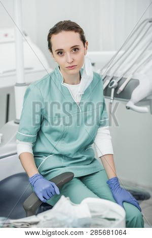 Selective Socus Of Upset Female Dentist Sitting In Dental Clinic