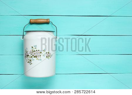 Enameled Milk Can On A Blue Wooden Background. Top View