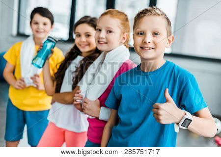 Smiling Kids With Towels Posing After Training In Gym