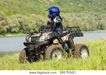 The Boy Is Traveling On An Atv.