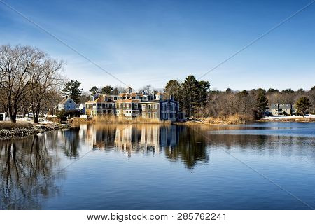 A Large Mansion Reflecting Off The Waters Of The Batson River In Kennebunkport Maine On A Cold Sunny